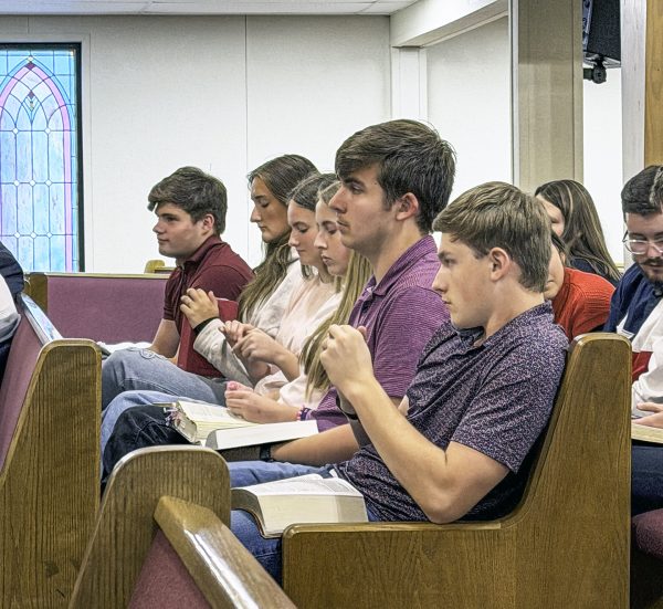 Teens listen and take notes in their Bibles as Steve Pearce speaks during the Show Me State Bible Lectures.