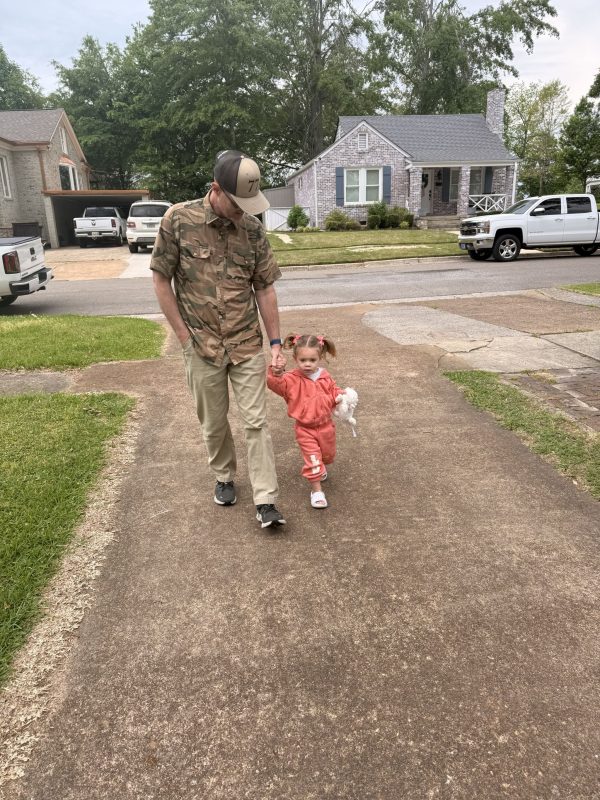 Chris McCurley walks down the driveway holding the hand of his granddaughter, Ash Jobe.