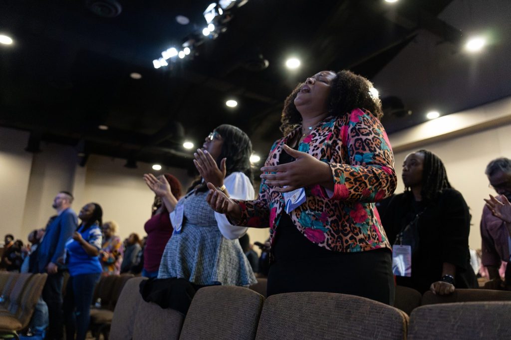 Nehemiah Next Level Up Summit attendees raise their hands in worship to God.