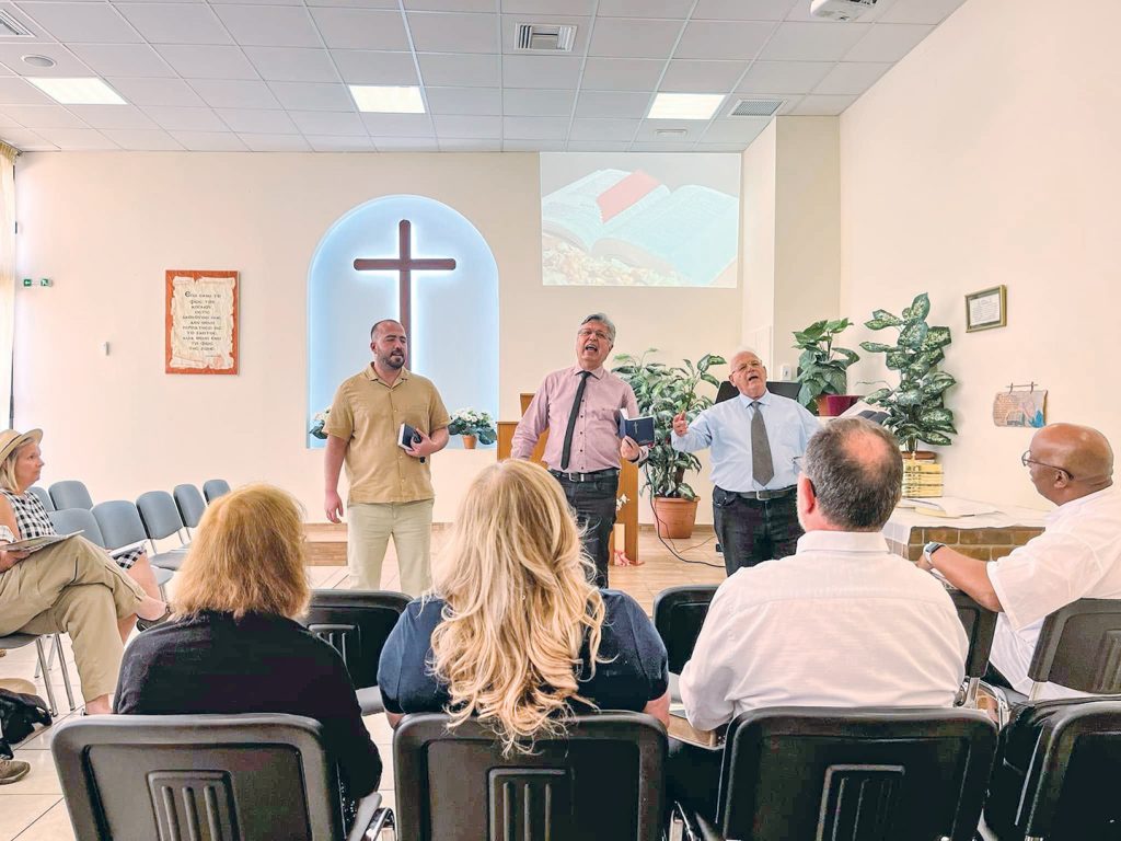 Ministers for the Glyfada Church of Christ in Athens, Greece, sing during a worship service. From left, they are Ebrahim Fatahi, Dimitrios Argyropoulos and Dino Roussos.