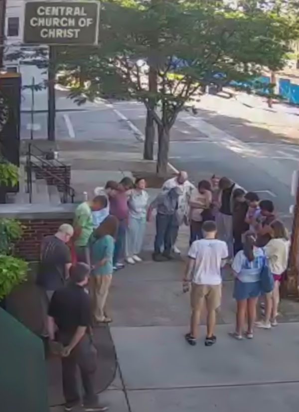 Members of the Central Church of Christ congregation gather in a prayer circle while members of the response team work to save Keith Braud's life.