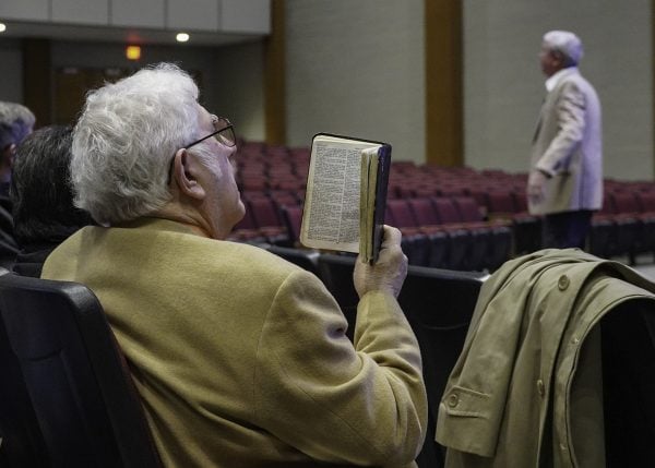 Don Reel, left, follows along in the book of Acts as FHU president David Shannon speaks on "Want to Grow Spiritually? Surrender to His Lordship."