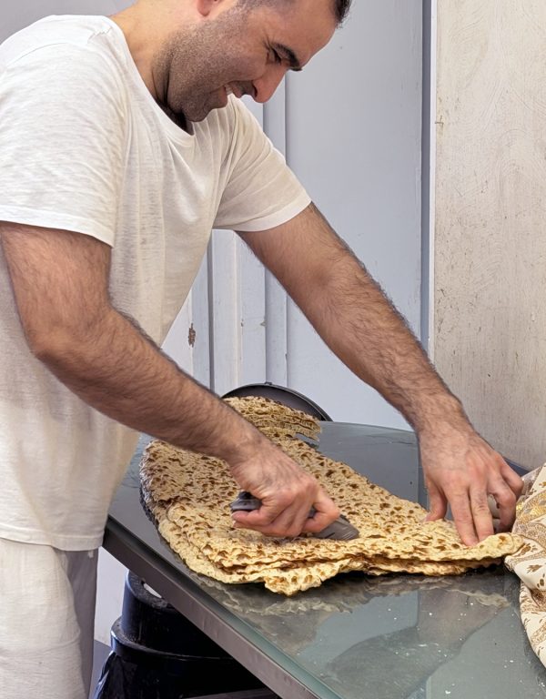 A worker at an Iranian supermarket in Birmingham, England, prepares a to-go order of sangak.